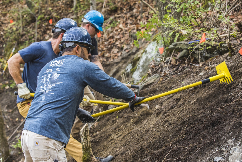 Three people building trail, funded by Shimano's Dig In program