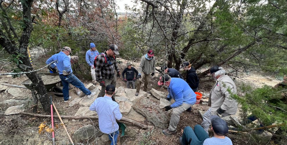 Members and volunteers from the Weatherford, Texas Mountain Bike Club work together to create new trail infrastructure.