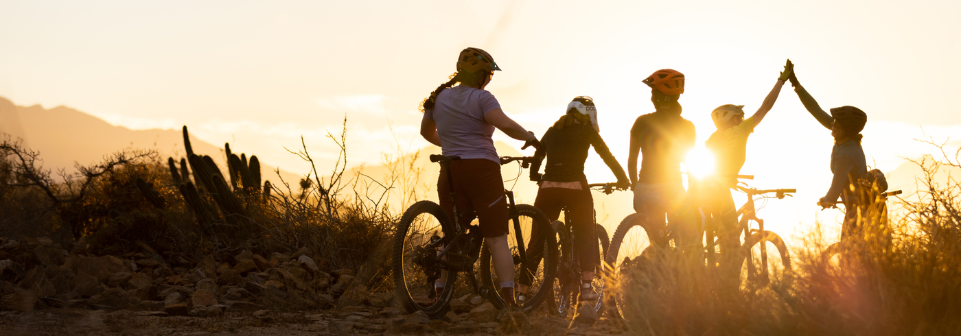 mountain bikers gather at sunset