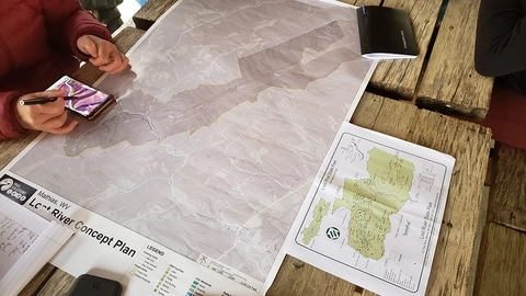 A concept map of Lost River State Park and hands holding a smartphone with a  topographic map on screen. 