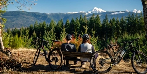 Two bikers sit side by side looking out into the view near Steamboat Springs, CO. 