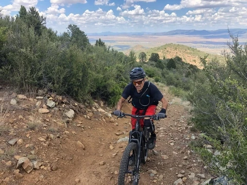 Rider on an eMTB climbing up a trail